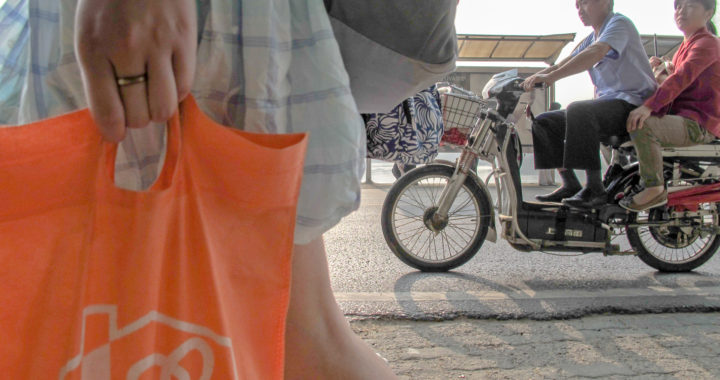 Woman carries orange shopping bag