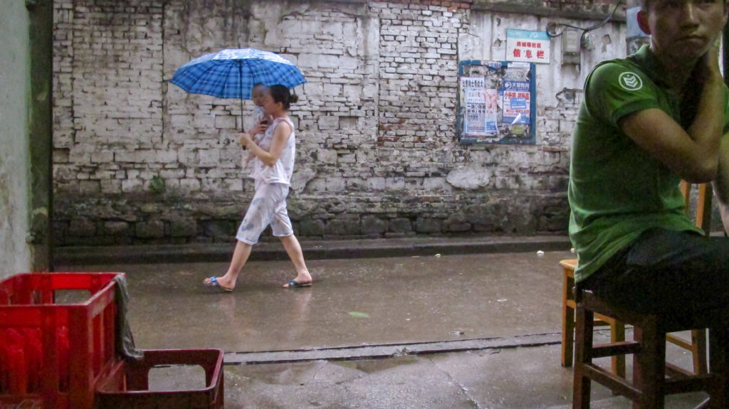 Women carries baby under umbrella