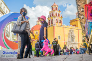 Girl holds pick unicorn in front of the Basilica of Our Lady of Guanajuato front of