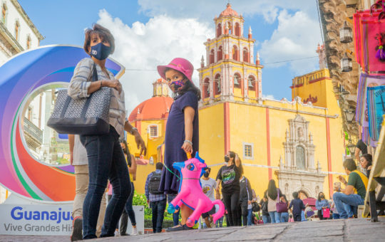 Girl holds pick unicorn in front of the Basilica of Our Lady of Guanajuato front of
